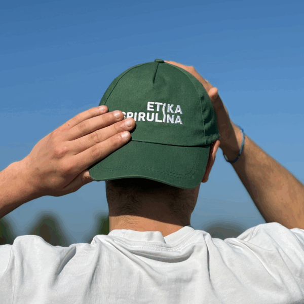 Membre de l’équipe vu de dos portant une casquette Etika Spirulina dans un cadre de production fermière bio