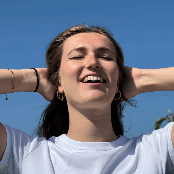 Portrait souriant d’un membre d’Etika Spirulina avec un comprimé de spiruline bio entre les dents