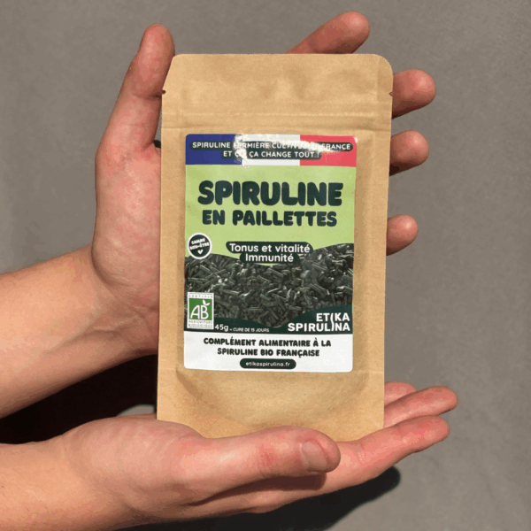 achet de 45g de spiruline bio en paillettes Etika Spirulina tenu dans deux mains